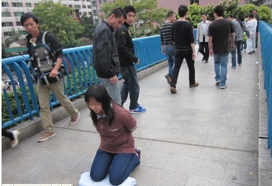 重庆女子自我"绑架"当街下跪 称抗议黑驾校