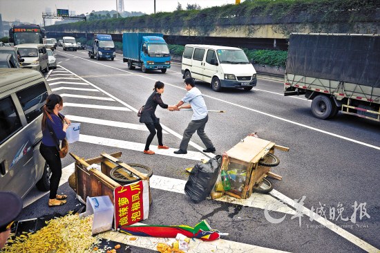 穿便衣的执法人员跟随小贩进入内环高架桥收缴小贩的手推车 羊城晚报记者 陈文笔 摄