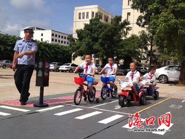 小学生们在交警的指导下体验在道路上按规定行驶。   