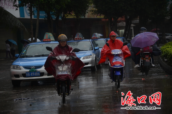 市民披着雨具出行