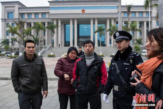 图为遇害孕妇的丈夫蔡世勇(左三)在法院门口等候