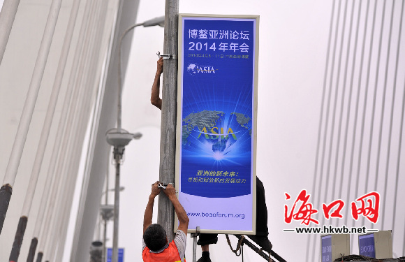 4月1日下午，工人正在世纪大桥上安装迎接博鳌亚洲论坛2013年年会广告灯箱