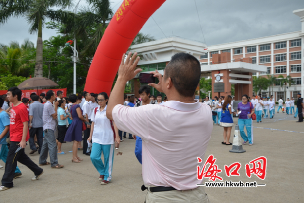 一名家長(zhǎng)給正在走出考場(chǎng)的孩子拍照AA