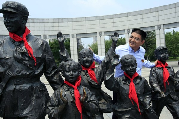 2014年7月1日，辽宁抚顺，陈光标在雷锋纪念馆与雷锋的铜像合影。