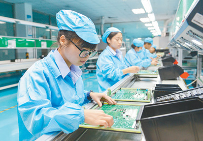 在南昌嘉捷鑫源科技有限公司厂房内,工人正在pth线上进行插件作业.