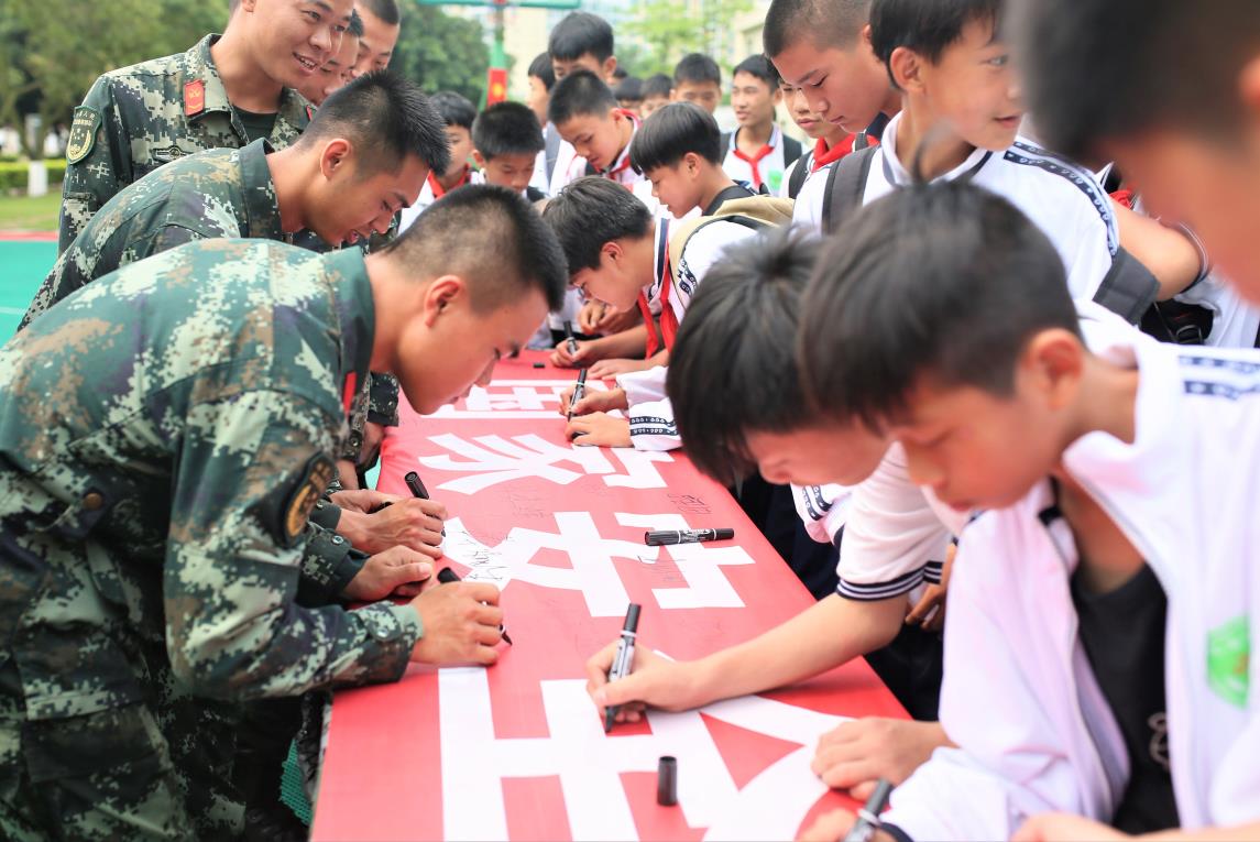 2019年4月12日，武警官兵和学生们一同在“国家安全、人人有责”的横幅上签名留念