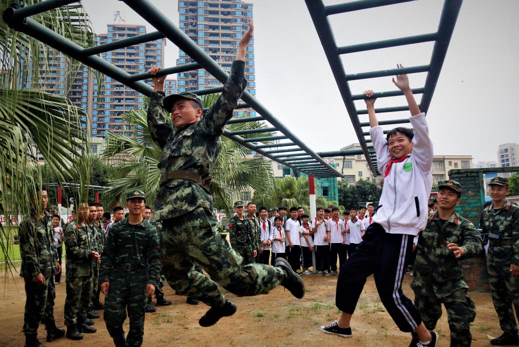 2019年4月12日，一名学生和武警官兵在进行通过云梯比赛