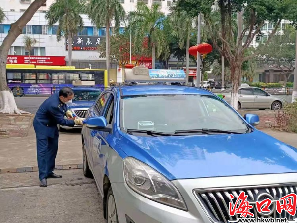 下洋坡加气站消毒点工作人员在为出租车消毒.(海口市运管处供图)