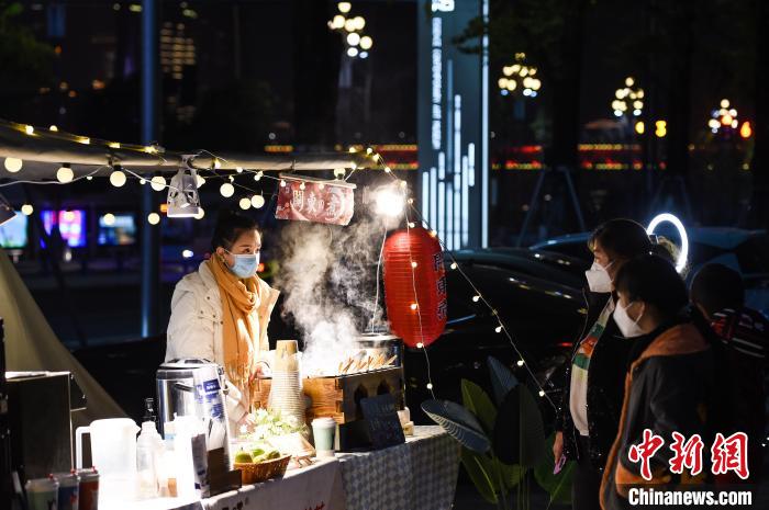 12月14日晚，重慶市民在南岸區南濱路的小熊集市上選購美食?！『闻罾?攝
