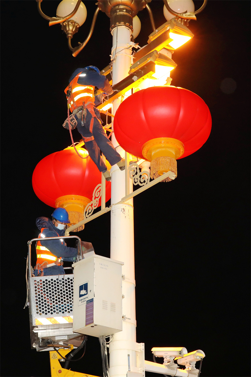 北京電力城市照明管理中心工作人員互相配合安裝大紅燈籠。張超攝