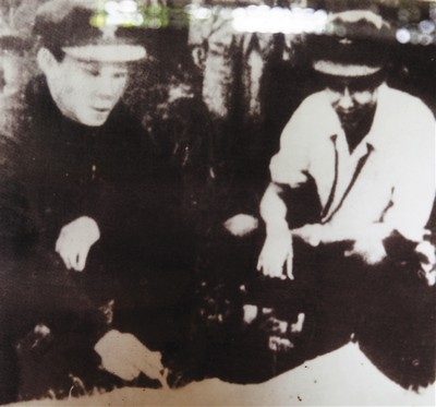 冯白驹(左)与琼崖纵队副司令员吴克之在研究作战方案.记者张茂翻拍