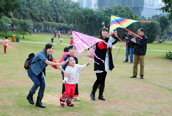 志愿者陪孩子们在万绿园放风筝.记者 张俊其 摄