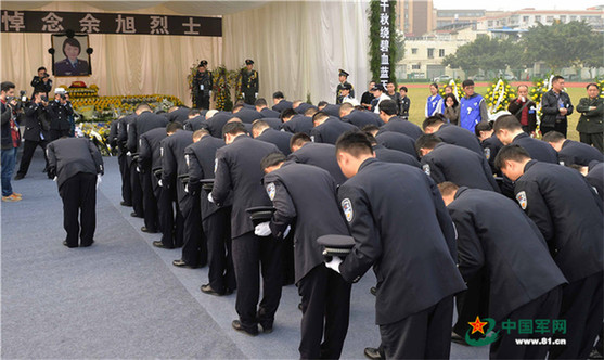 公安干警向余旭烈士脱帽鞠躬.沈玲 摄
