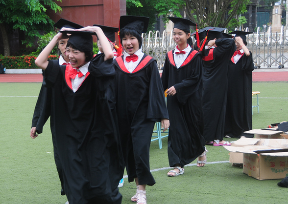 又到一年毕业时,图为滨海九小六年级的学生们,穿上"博士服"拍摄毕业照